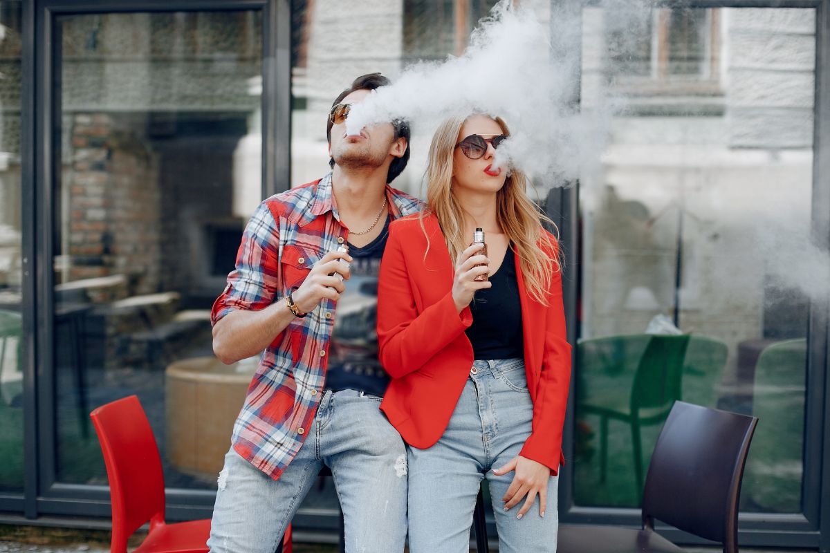 A guy and a girl vaping outside the airport