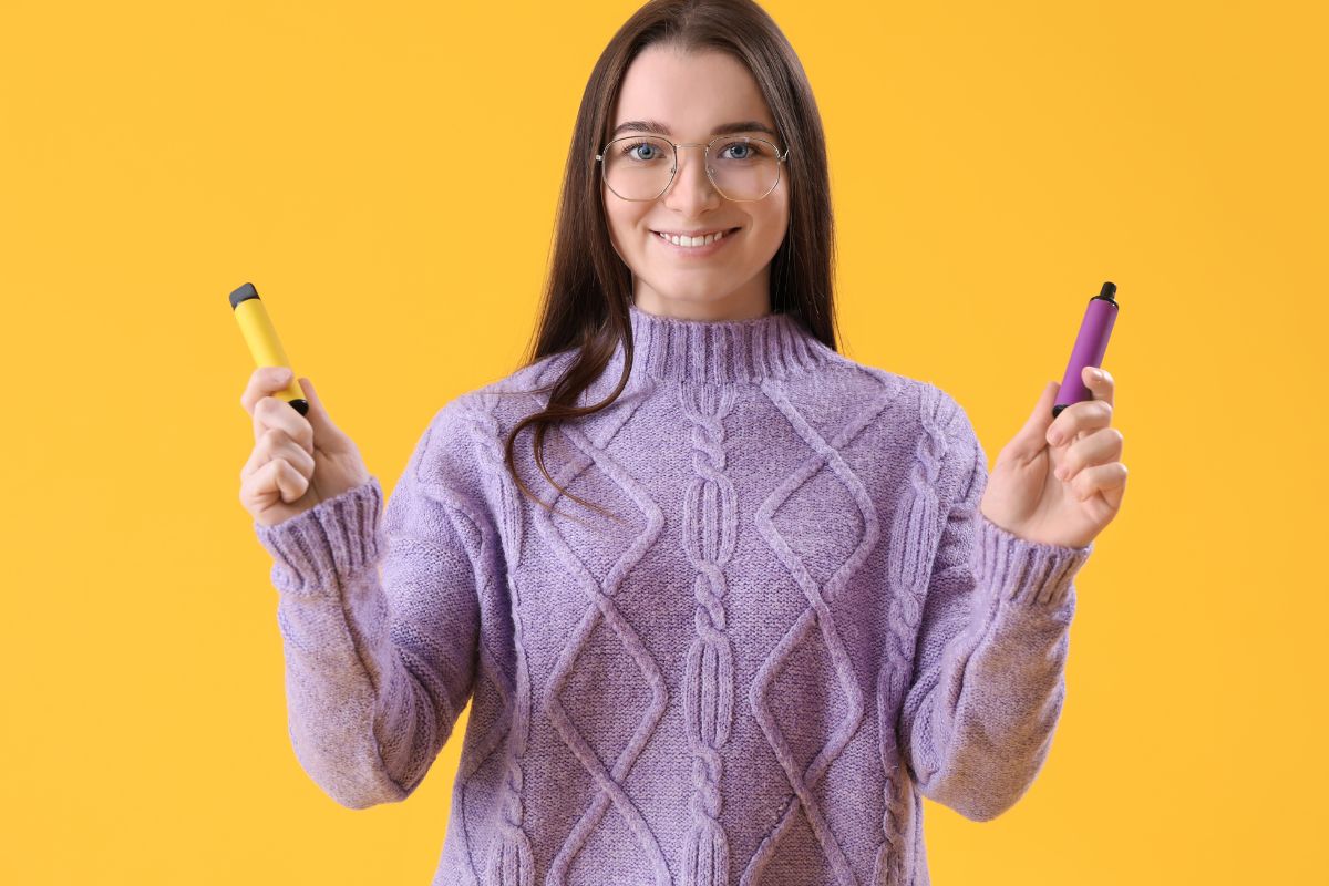 A girl holding two elf bar vapes in her hand