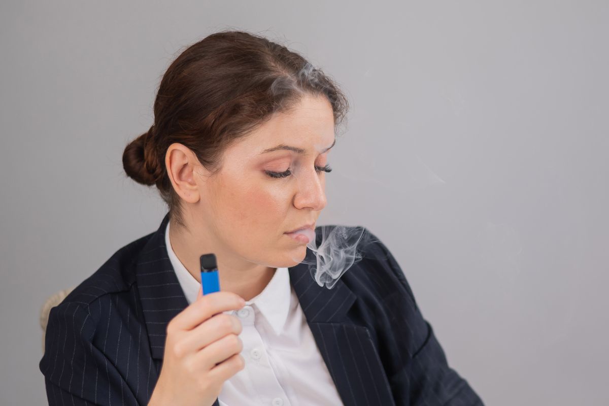 A lady smoking ELF bar disposable vape in her office